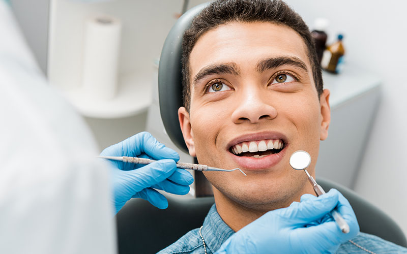 A young man smiling during a dental checkup.